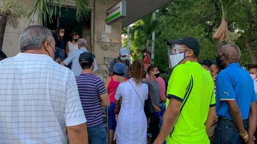 La gente hace fila frente a una sucursal bancaria en La Habana para depositar dólares estadounidenses antes de que entre en vigencia un nuevo decreto que suspenderá dichos depósitos en los bancos de Cuba.
