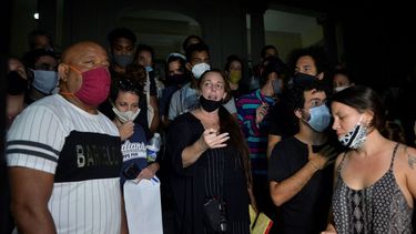 La artista cubana Tania Bruguera (centro) es una de las personas que ha sido secuestrada por el régimen y sometida a interrogatorios por demandar cambios en Cuba. En la foto la artista lee los puntos de discusión frente a las puertas del Ministerio de Cultura luego de una reunión con el Viceministro de Cultura en La Habana, el 28 de noviembre de 2020.
