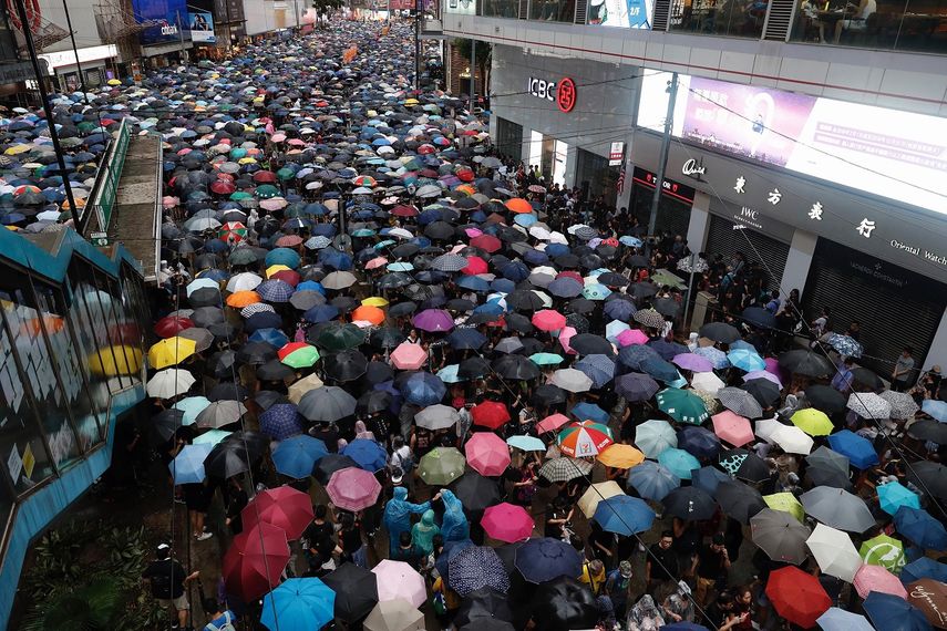 Manifestantes con paraguas marchan por una calle en Hong Kong, el domingo 18 de agosto del 2019.