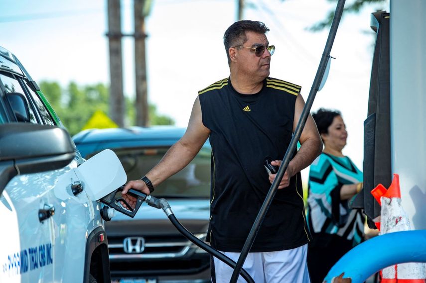 Un conductor repone gasolina en su auto.