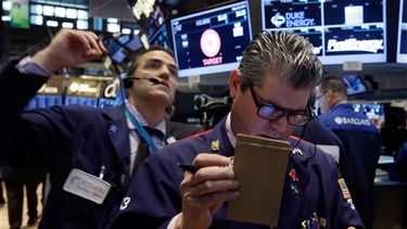 Los corredores de bolsa Gregory Rowe, izquierda, y John Panin laboran en el piso de la Bolsa de Valores de Nueva York el viernes 30 de mayo de 2014. Dos informes negativos sobre los consumidores estadounidenses impulsaron los mercados a la baja, pero d