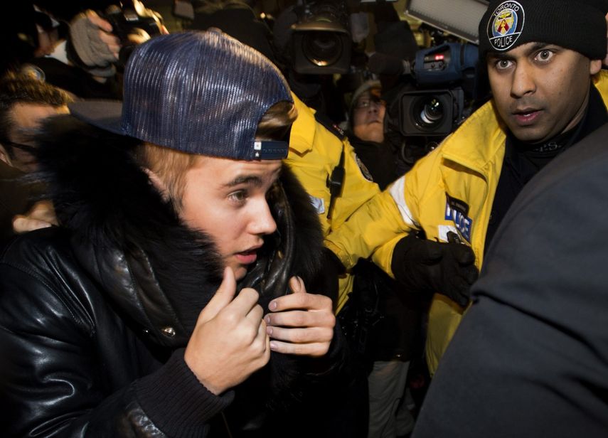 El cantante canadiense Justin Bieber ingresa a la comisaría para entregarse a la policía de Toronto para enfrentar un cargo de agresión, el miércoles 29 de enero de 2014. (AP)