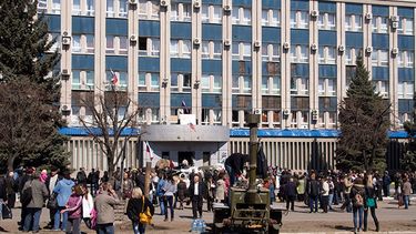 Activistas prorrusos se congregan frente a la entrada de la oficina del Servicio de Seguridad ucraniana en Luhansk, 30 kilómetros (20 millas) al oeste de la frontera con Rusia, en Ucrania, el martes 8 de abril de 2014. (AP)