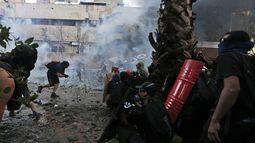 Manifestantes antigubernamentales son rociados por un ca&ntilde;&oacute;n de agua de la polic&iacute;a durante enfrentamientos en Santiago, Chile, el viernes 13 de diciembre de 2019.