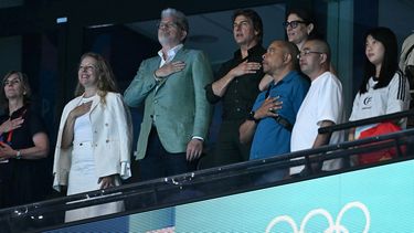 El actor estadounidense Tom Cruise canta el himno nacional de Estados Unidos durante la ceremonia de victoria del evento femenino de natación con relevos estilo libre 4x100 m en los Juegos Olímpicos de París 2024.