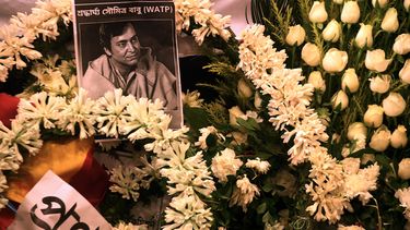 Una foto del fallecido actor indio Soumitra Chatterjee se ve en guirnaldas colocadas junto a su cuerpo durante su funeral en Calcuta el 15 de noviembre de 2020.&nbsp;
