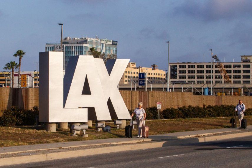 Pasajeros caminan con sus equipajes en los alrededores del Aeropuerto Internacional de Los Ángeles, el 15 de mayo de 2026.
