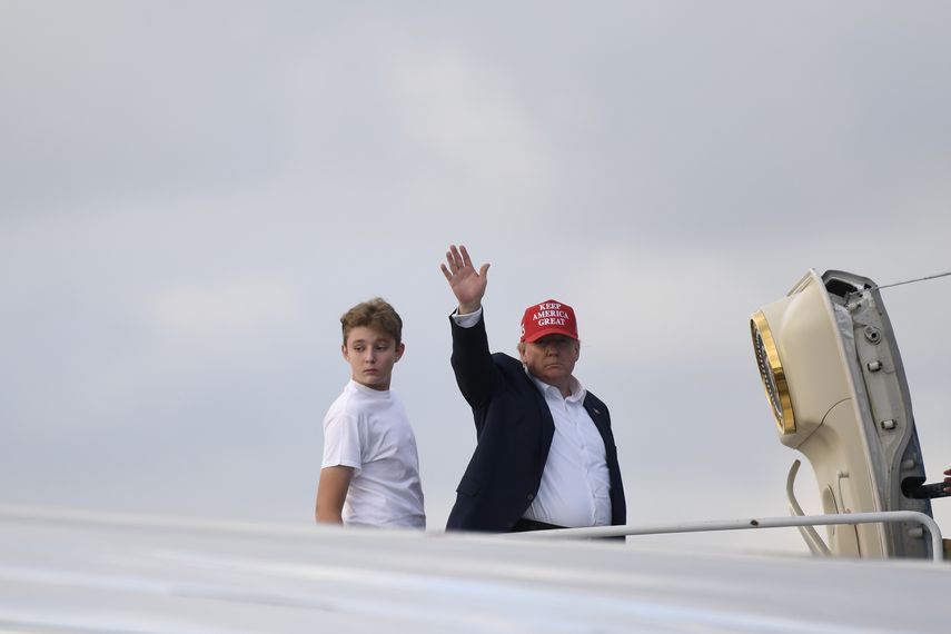 El presidente Donald Trump, junto a su hijo Barron, saluda desde la entrada al avi&oacute;n presidencial, en el Aeropuerto Internacional de Palm Beach, en West Palm Beach, Florida, el domingo 1 de diciembre de 2019.&nbsp;