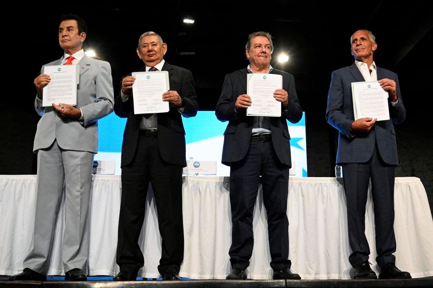 Los candidatos presidenciales hondureños Salvador Nasralla (izq.), Mario Rivera (2.º der.), Nasry Asfura (der.) y el exjefe de las Fuerzas Armadas, Mario Raúl Pacheco (2.º izq.), muestran el Acuerdo Democrático para la Defensa del Voto tras su firma en Tegucigalpa el 11 de noviembre de 2025.&nbsp;