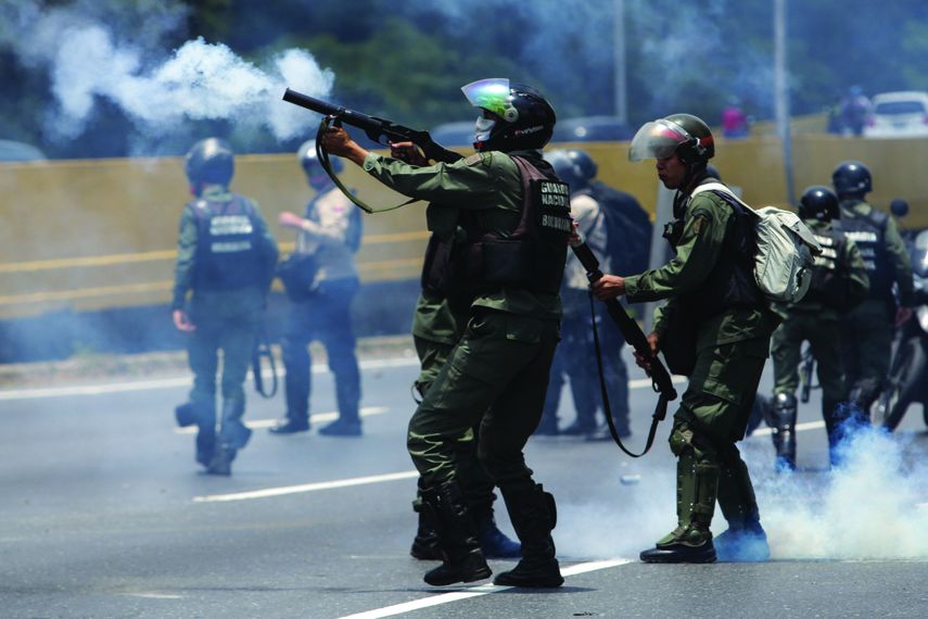 Miembros de la Guardia Nacional Bolivariana lanzan gases lacrimógenos a los manifestantes en Caracas.