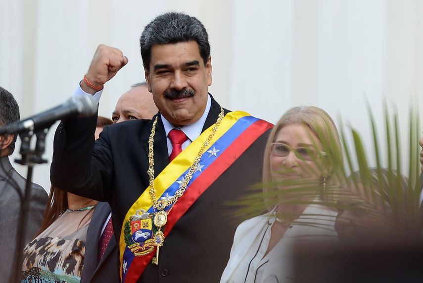 El dictador venezolano Nicolás Maduro alza un puño a su llegada al edificio de la Asamblea Nacional Constituyente durante una conmemoración del 20mo aniversario de la Constitución, en Caracas, Venezuela, el domingo 15 de diciembre de 2019. A la derecha está su esposa Cilia Flores.