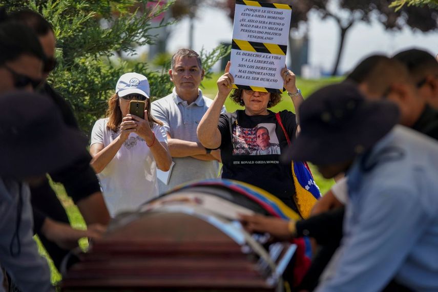 Una persona muestra un letrero de protesta durante el entierro del exteniente venezolano Ronald Ojeda en el cementerio Canaan en Santiago, Chile, el viernes 8 de marzo de 2024. De acuerdo con el fiscal Héctor Barros, Ojeda fue secuestrado el 21 de febrero y encontrado muerto enterrado a las afueras de la capital el 1 de marzo.&nbsp;
