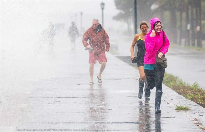  Turistas de la ciudad de Charleston intentan cubrirse ante la fuerte lluvia caída por el paso del huracán Joaquín (EFE)