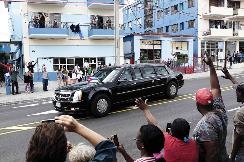 Habaneros saludan la caravana del presidente Obama rumbo al estadio de beisbol. (EFE)