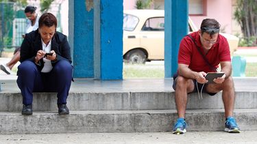 Varias personas navegan por internet con sus celulares desde un portal en La Habana el 15 de enero de 2019.