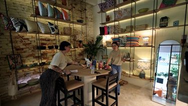 Personas organizando productos en un negocio en La Habana, Cuba.