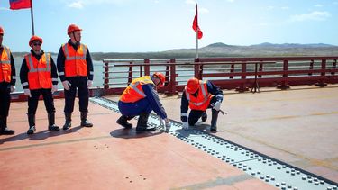 Esta imagen, distribuida por el Ministerio de Transportes de Rusia el 21 de abril de 2026, muestra una ceremonia que conmemora la conexión de las dos orillas del nuevo puente de carretera Rusia-Corea del Norte sobre el río Tumen, cuya inauguración está prevista para este verano.&nbsp; 