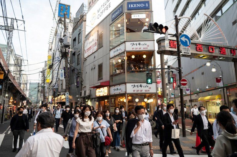 La gente camina por la calle en el área de Shimbashi de Tokio el 21 de junio de 2021, después de que Japón anunció que el 20 de junio se levantó el estado de emergencia por virus en Tokio y varias otras regiones, poco más de un mes antes de los Juegos Olímpicos