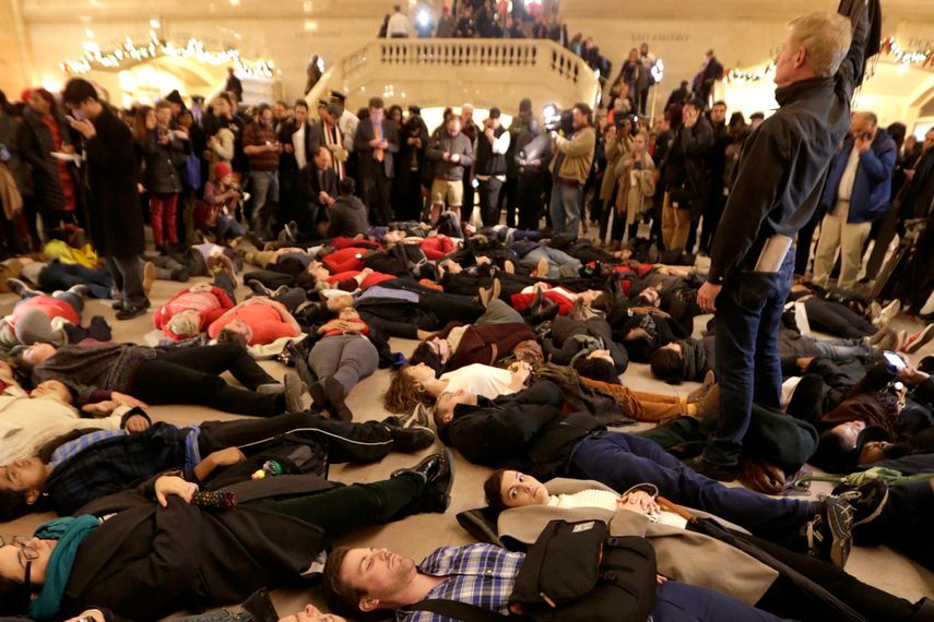 Un grupo de personas se tumba en el suelo de la estacion Grand Central Terminal tras el anuncio de un jurado investigador de no acusar a un agente de la policía de Nueva York por la muerte de Eric Garner, el 3 de diciembre de 2014, en Nueva York. (AP)