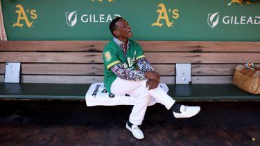 El miembro del Salón de la Fama de las Grandes Ligas, Rickey Henderson, se sienta en el dugout antes de un juego entre los Rangers y los Atléticos, el 26 de septiembre de 2024. 