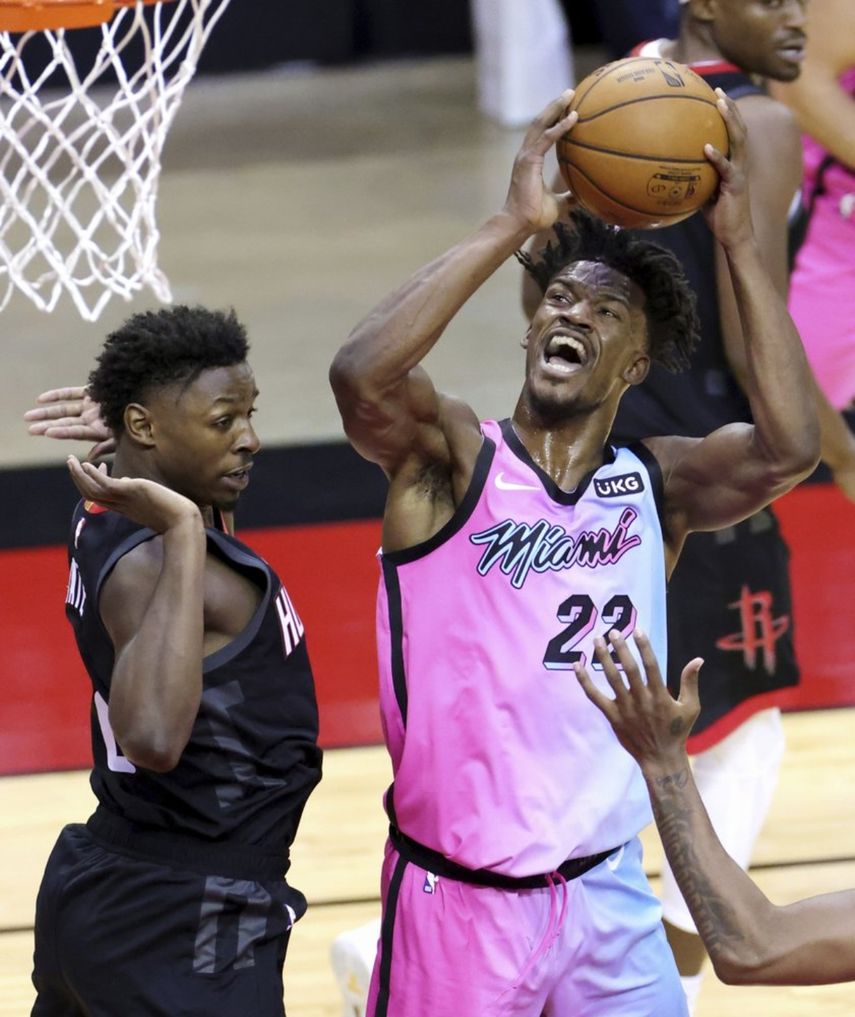 Jimmy Butler de Miami Heat dispara junto a JaeSean Tate de los Rockets de Houston durante el primer cuarto de un juego de baloncesto de la NBAen Houston