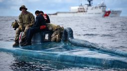 Miembros de la Guardia Costera de EEUU a bordo de un semisumergible incautado, presuntamente un buque de contrabando, en aguas internacionales del Océano Pacífico Oriental, mientras el escampavía Harriet Lane maniobra en las cercanías el 24 de octubre de 2019. El semisumergible fue interceptado el día anterior por la tripulación del Harriet Lane.