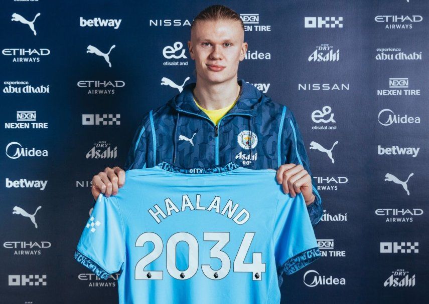 El noruego Erling Haaland muestra la camiseta del Manchester City con el año en el que expira su nuevo contrato