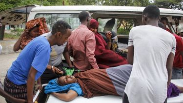 Trabajadores m&eacute;dicos y otros somal&iacute;es ayudan a una mujer que result&oacute; herida cuando un coche bomba explot&oacute; frente al Hotel Elite, el domingo 16 de agosto de 2020, en Mogadiscio, Somalia.&nbsp;