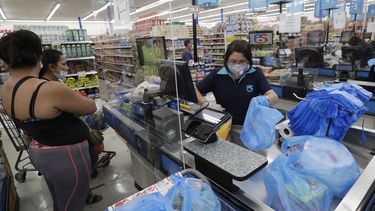La cajera Rosario Vargas (al centro) coloca productos en bolsas en el supermercado Presidente en La Peque&ntilde;a Habana, en Miami.&nbsp; &nbsp;