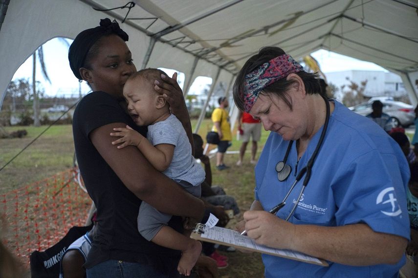 Una mujer sostiene a un beb&eacute; para ser atendido en una tienda-hospital por Samaritans Purse tras el hurac&aacute;n Dorian en Freeport, Bahamas, el martes 10 de septiembre de 2019. Miles de sobrevivientes de huracanes se enfrentan a la perspectiva de comenzar de nuevo sus vidas, pero con poca idea de c&oacute;mo o d&oacute;nde comenzar.&nbsp;