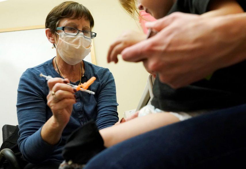 Deborah Sampson, a la izquierda, una enfermera en una clínica de la Universidad de Washington Medical Center en Seattle, aplica una inyección de la vacuna Pfizer COVID-19 a un niño de 20 meses de edad.