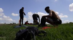 Migrantes esperando a ser procesados por la Patrulla Fronteriza tras cruzar de forma ilegal el Río Bravo desde México y hasta Estados Unidos, en Eagle Pass, Texas, el viernes 26 de agosto de 2022.&nbsp;