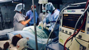 Médicos realizan procedimiento quirúrgico a una paciente.
