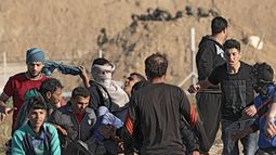 Manifestantes palestinos llevan a un joven herido durante los enfrentamientos con las tropas israelíes a lo largo de la frontera entre Israel y la franja de Gaza.