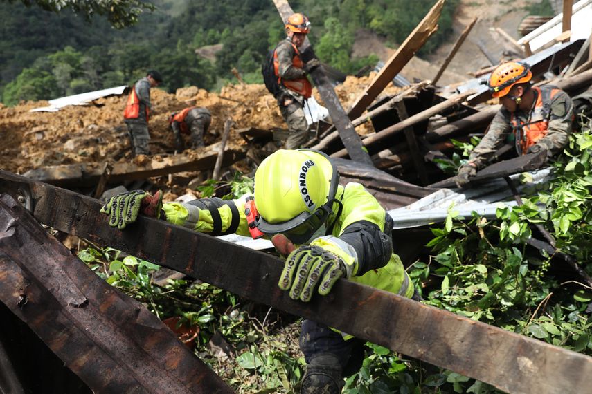 Equipos de rescatistas buscan sobrevivientes entre los restos de un enorme alud de tierra provocado por la lluvia en el poblado de Quejá,