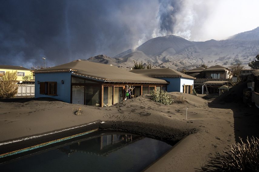 Cristina Vera sale de su casa cubierta de ceniza por la erupción de un volcán tras recoger sus últimas pertenencias, en la isla canaria de La Palma, España, el lunes 1 de noviembre de 2021.&nbsp;