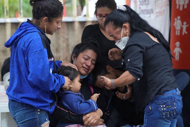La gente espera fuera de la morgue para que se liberen los cuerpos de los familiares encarcelados después de que fueron asesinados durante un motín mortal dentro de la cárcel de Bellavista en Santo Domingo de los Tsachilas, Ecuador, el martes 10 de mayo de 2022