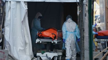 Personal de salud traslada&nbsp;un cuerpo&nbsp;a un cami&oacute;n frigor&iacute;fico que sirve como dep&oacute;sito temporal de cad&aacute;veres en el Hospital Wyckoff en Brooklyn, Nueva York.