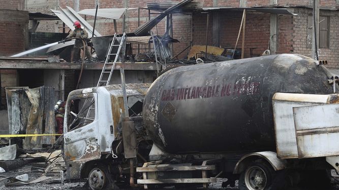 Un bombero enfr&iacute;a con agua el techo de un cami&oacute;n cisterna de gas que explot&oacute; en el barrio de Villa Mar&iacute;a en Lima, Per&uacute;, el jueves 23 de enero de 2020. La explosi&oacute;n dej&oacute; dos muertos, aproximadamente 50 personas heridas y al menos una docena de casas quemadas.&nbsp;