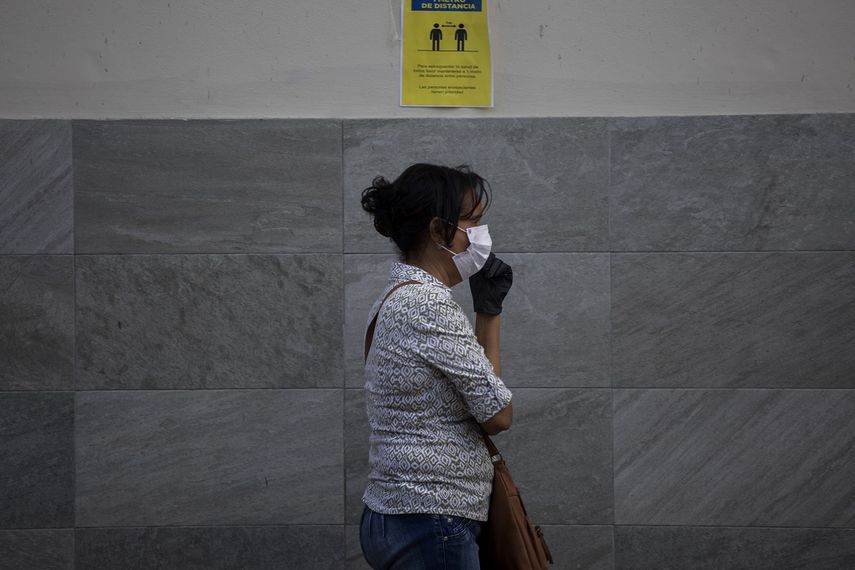 Una mujer usa una mascarilla mientras camina frente a un centro de salud en Santo Domingo, Rep&uacute;blica Dominicana, el 30 de marzo de 2020.