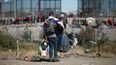 Migrantes carga varias mochilas mientras se dirige hacia la barrera en entrada de la frontera con Estados Unidos desde Ciudad Juárez, México, el 27 de diciembre de 2023.&nbsp;