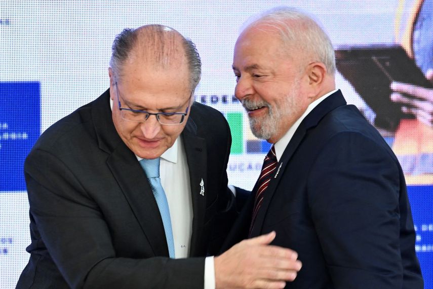 Lula en la pista aérea frente a un avión con los colores de Brasil, estrechando la mano de su vicepresidente Geraldo Alckmin