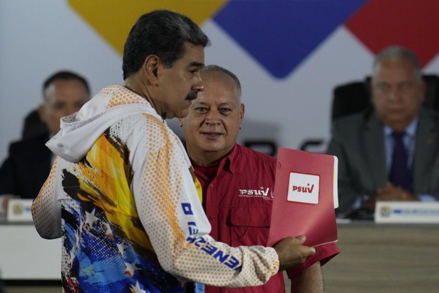 Nicolás Maduro sostiene un documento que le entrega Diosdado Cabello, que nombra a dictador Maduro como candidato del partido a la reelección