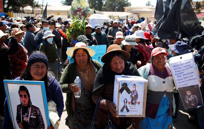 Residentes cargan ataúdes y fotos de los caídos durante la marcha fúnebre por los fallecidos durante los disturbios en Juliaca, Perú, el 11 de enero de 2023.