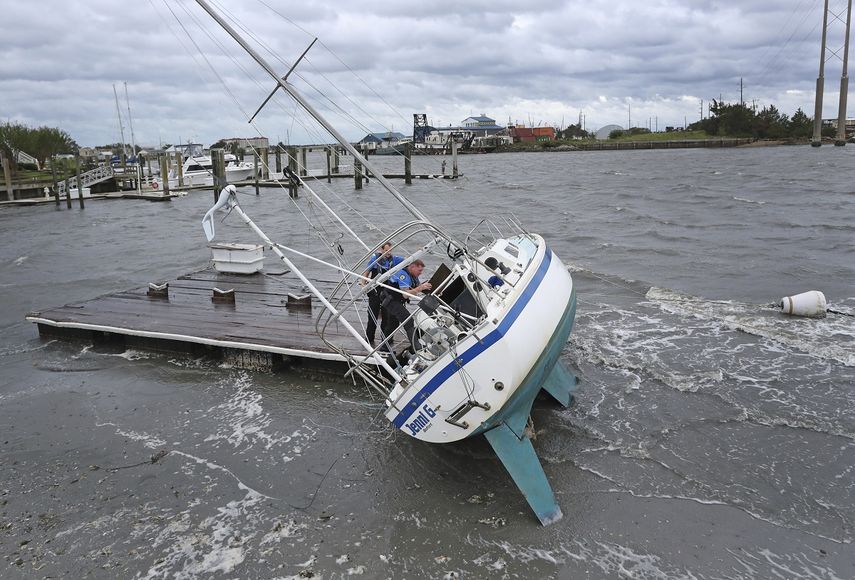 Los agentes de la polic&iacute;a de Beaufort Curtis Resor (izquierda) y Micheal Stepehens revisan un barco varado tras el paso del hurac&aacute;n Dorian por Beaufort, en la costa de Carolina del Norte. (AP Foto/Tom Copeland)