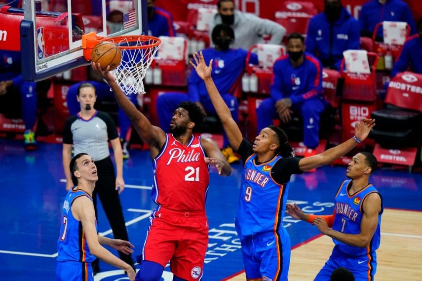 El pívot camerunés Joel Embiid (21), de los 76ers de Filadelfia, intenta encestar frente a Moses Brown (9), Aleksej Pokusevski, izquierda y Darius Bazley, del Thunder de Oklahoma City