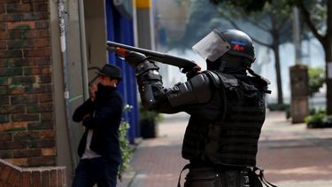 Un policía apunta una escopeta durante una protesta estudiantil en Bogotá, el sábado 23 de noviembre de 2019. Las autoridades colombianas mantienen una acentuada presencia policial y militar en la capital del país tras dos días de disturbios. 