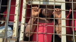 Un niño junto con personas detenidas para ser deportadas hacia Haití, en un camión policial, en un puente que conecta a Dajabón, República Dominicana, con Haití, el 18 de marzo de 2024. 