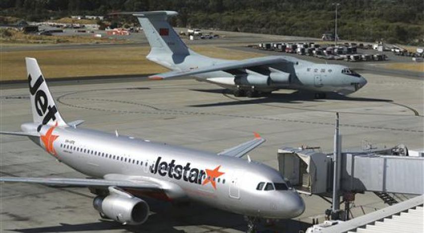 Un avión chino Ilyushin IL-76s pasa frente a una aeronave comercial en el Aeropuerto Internacional de Perth, Australia. (Foto AP/Rob Griffith)