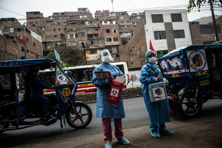 Trabajadores de la salud llegan para inocular a ancianos con dosis de la vacuna Pfizer-BioNTech contra COVID-19, a su casa del distrito El Agustino en Lima, Perú, el 28 de abril de 2021.